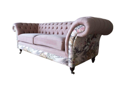 Un vivace divano Chesterfield a tre posti con delicato motivo floreale rosa.