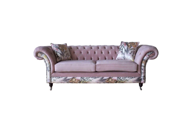 Un vivace divano Chesterfield a tre posti con delicato motivo floreale rosa.