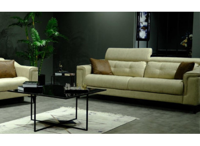 Salotto beige con divano in pelle a tre posti e struttura in legno.