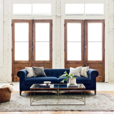 Divano Chesterfield in pelle o tessuto con 4 posti a sedere.