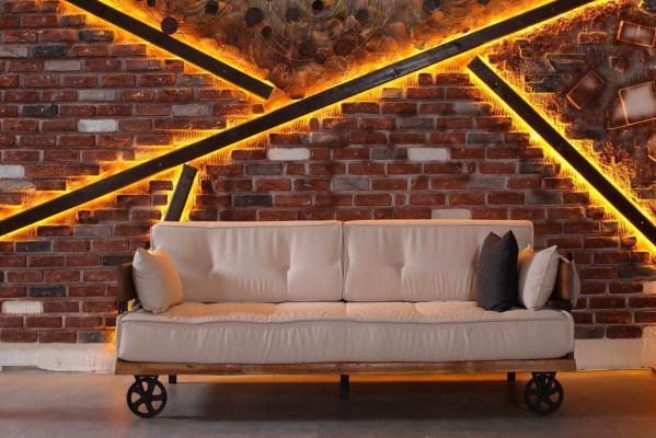 Divano a tre posti stile Gründerzeit, design loft, cuscini beige in tessuto.