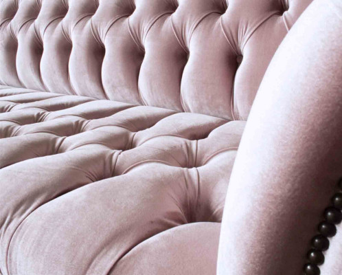 Divano Chesterfield rosa imbottito a 4 posti.