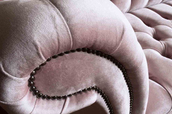 Divano Chesterfield rosa imbottito a 4 posti.