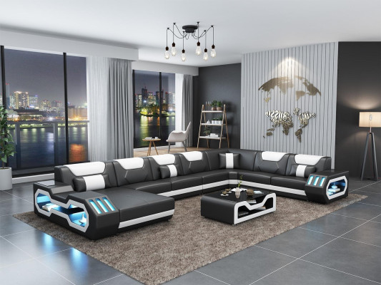 Divano a forma di L in pelle grigia con design moderno e tavolino.