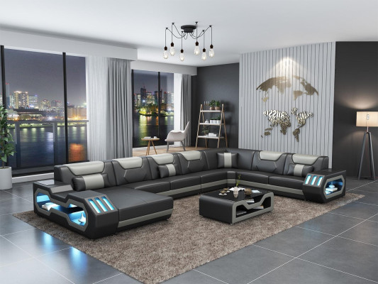 Divano a forma di L in pelle grigia con design moderno e tavolino.