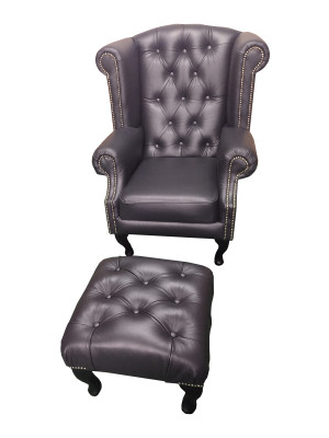 Lussuosa poltrona con poggia piedi Chesterfield in pelle nera moderna.