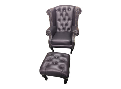 Lussuosa poltrona con poggia piedi Chesterfield in pelle nera moderna.