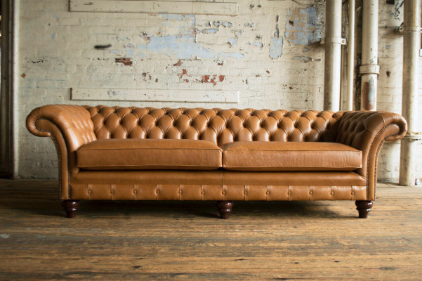 Divano Chesterfield marrone di lusso a 4 posti in tessuto imbottito.