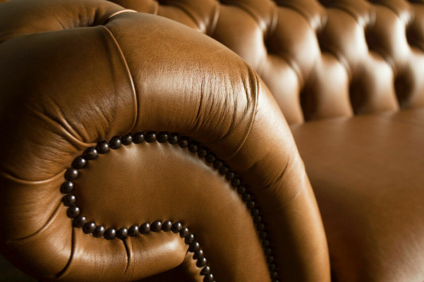 Divano Chesterfield marrone di lusso a 4 posti in tessuto imbottito.