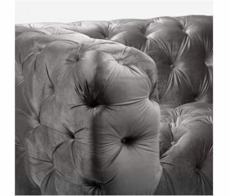 Divano Chesterfield grigio in stoffa o pelle con imbottitura.