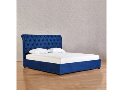 Letto matrimoniale Chesterfield blu in camera da letto di lusso con mobili imbottiti.