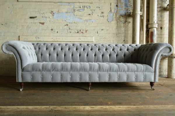 Classico divano Chesterfield 4 posti in pelle grigia, design imbottito.