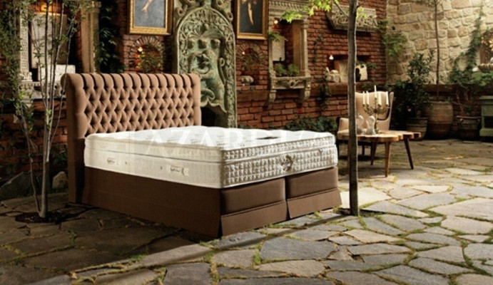 Camera da letto di lusso grigia con letto Chesterfield, design di imbottitura e letti matrimoniali di lusso.