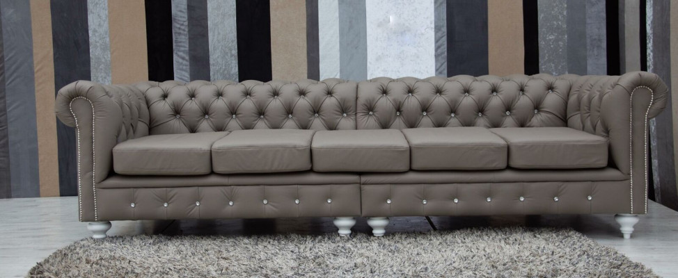 Divano Chesterfield in tessuto e pelle con imbottitura, composto da 5 posti.