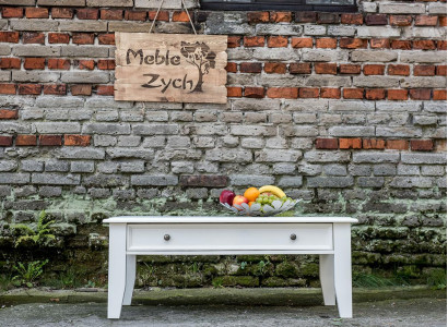 Soggiorno in stile rustico, tavolino artigianale in vero legno, divano e tavoli ausiliari.