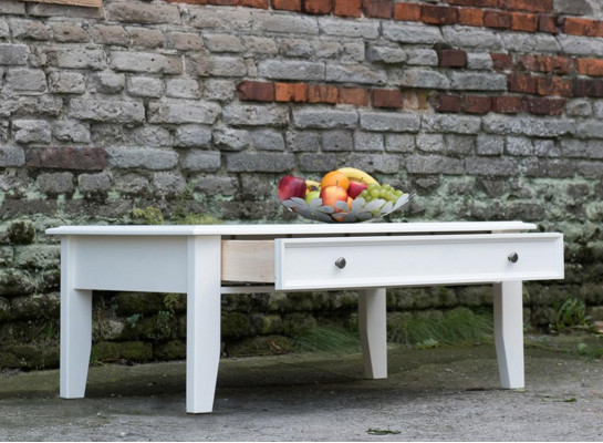 Soggiorno in stile rustico, tavolino artigianale in vero legno, divano e tavoli ausiliari.