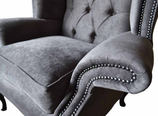 Poltrona Chesterfield con schienale alto in stoffa grigia per il soggiorno.