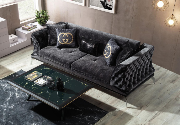 Divano nero Chesterfield a tre posti più uno per il salotto.