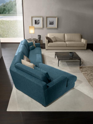 Divano design a L imbottito in tessuto blu per il soggiorno.