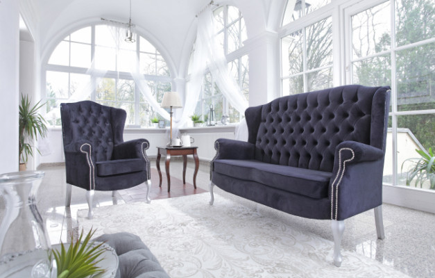 Classico divano Chesterfield a tre posti in velluto imbottito.