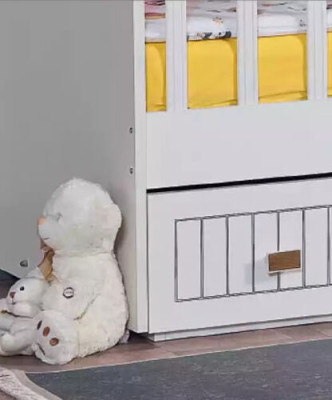 Lettino per bambini con cassettone bianco in stile per la camera dei bambini.