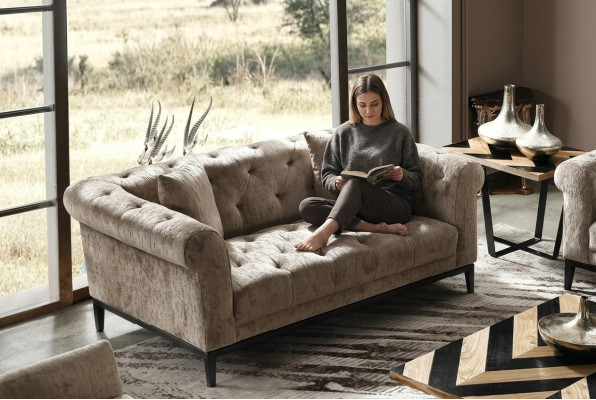 Accogliente divano Chesterfield beige a tre posti per il soggiorno.