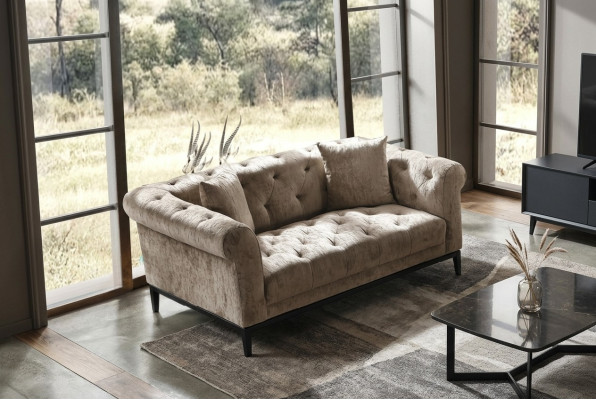 Accogliente divano Chesterfield beige a tre posti per il soggiorno.