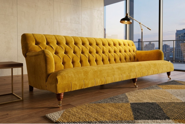 Divano Chesterfield classico a 4 posti in pelle gialla design imbottito.