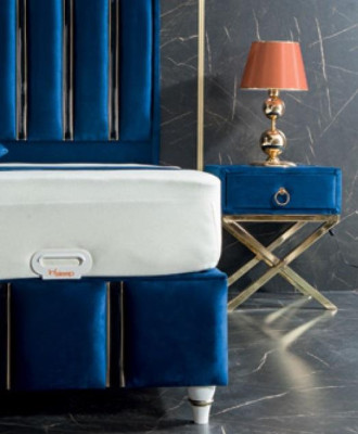 Letto da designer blu zaffiro con comodini su gambe d'acciaio dorato.