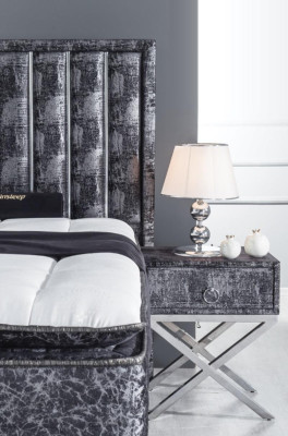 Letto nero con materasso e due comodini nel set di mobili da camera da letto.