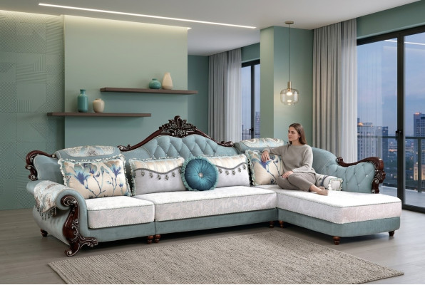 Divano classico in tessuto Chesterfield angolare con pouf e cuscini.