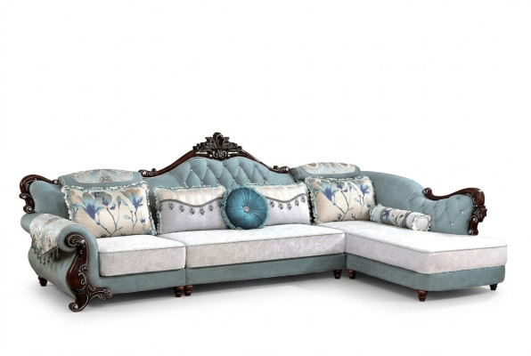 Divano classico in tessuto Chesterfield angolare con pouf e cuscini.