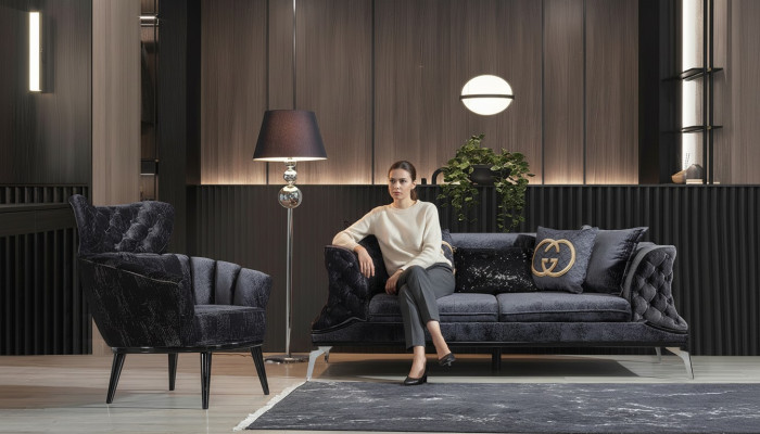 Divano nero Chesterfield a tre posti più uno per il salotto.