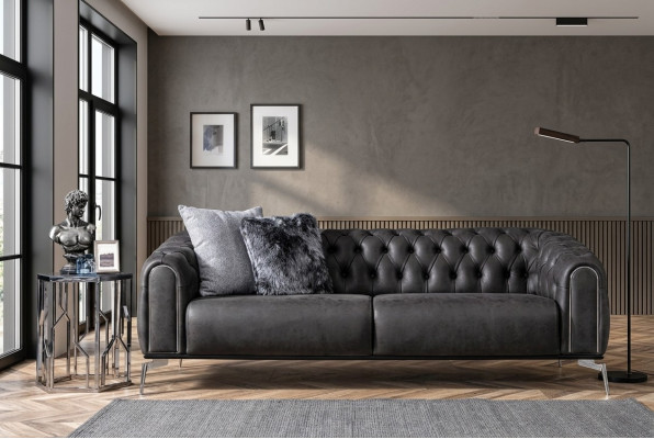 Divano nero dritto a quattro posti in stile Chesterfield per il soggiorno.