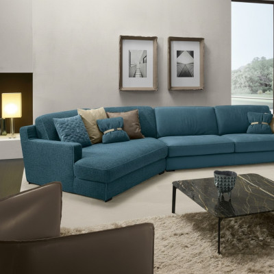 Divano design a L imbottito in tessuto blu per il soggiorno.