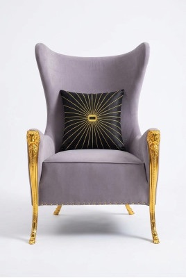 Poltrona di lusso con elementi decorativi e gambe dorate.