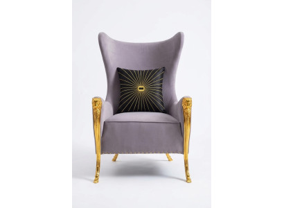 Poltrona di lusso con elementi decorativi e gambe dorate.