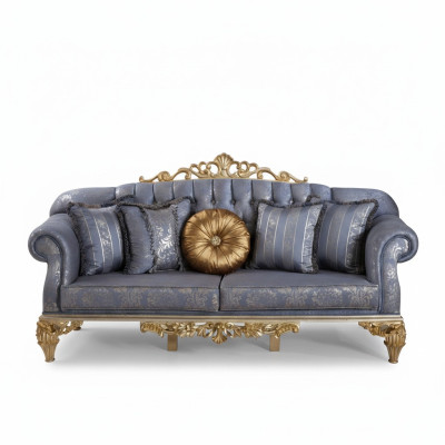 Divano classico e sofisticato in stile Chesterfield per il soggiorno con cuscini dorati.