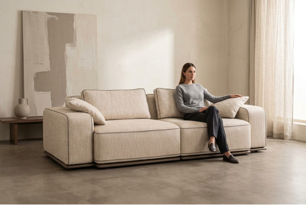 Divano a tre posti moderno beige in tessuto.