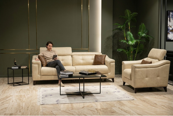 Salotto beige con divano in pelle a tre posti e struttura in legno.