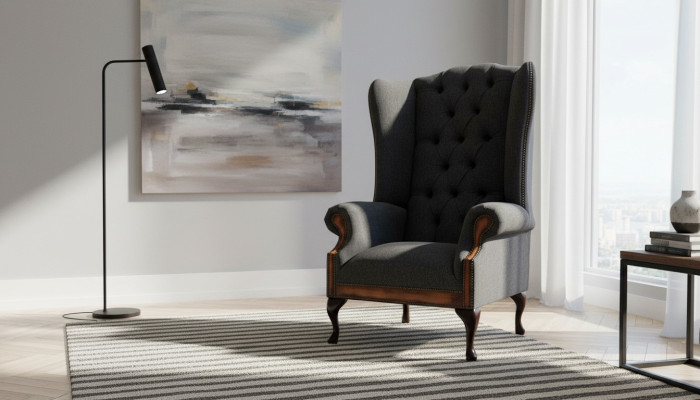 Poltrona Chesterfield grigia in tessuto classico per il soggiorno.