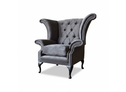 Poltrona Chesterfield con schienale alto in stoffa grigia per il soggiorno.