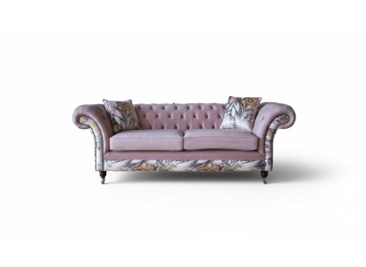 Un vivace divano Chesterfield a tre posti con delicato motivo floreale rosa.