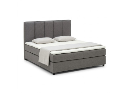 Letto boxspring continentale a due piazze con alto rivestimento in pelle tessile.